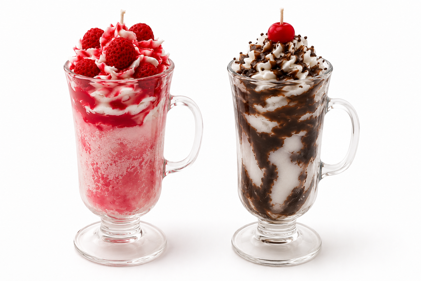 Two tall clear glass mugs filled with whipped dessert on a white background. The left mug contains a pink-red frozen drink topped with whipped cream, raspberries, and a cherry.