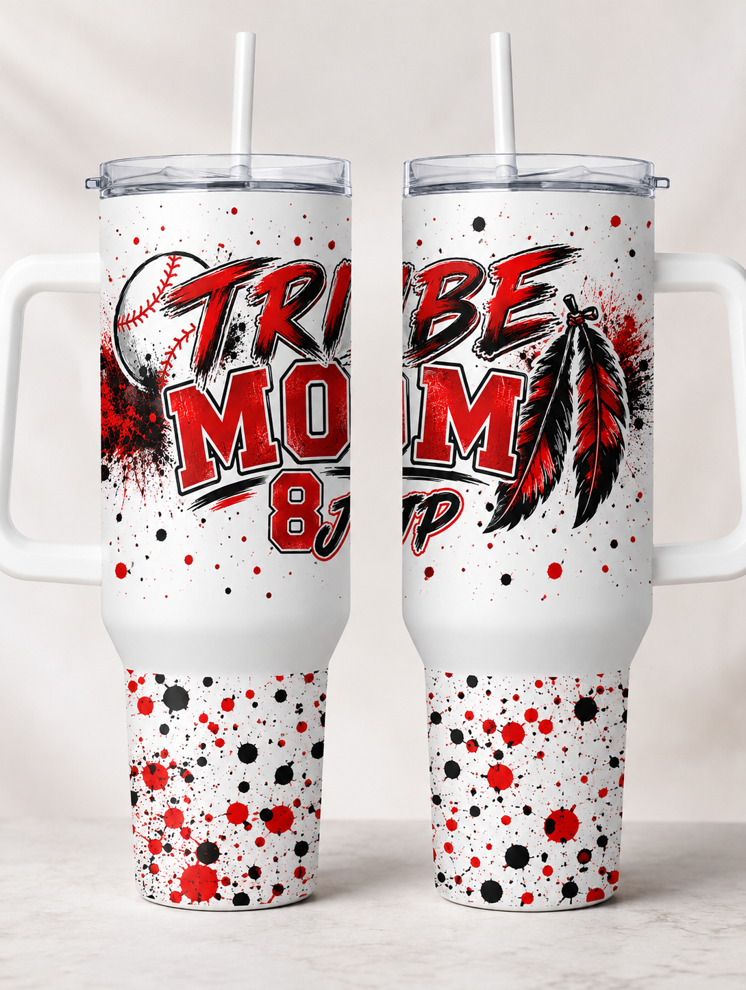 Two white handled travel tumblers with clear lids and straws, shown side by side. The tumblers feature a red, black, and white graphic design with the words 'TRIBE MOM' and a baseball and feather motif.