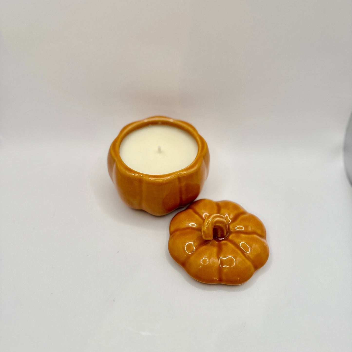 Two small pumpkin-shaped candle holders on a white background