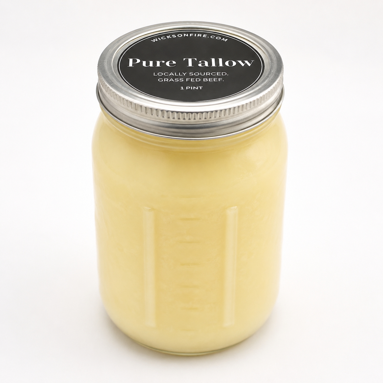 A 1 pint glass jar candle with a silver metal lid and a black label reading 'Pure Tallow' by Wickson Fire, filled with pale yellow wax, shown on a white background.