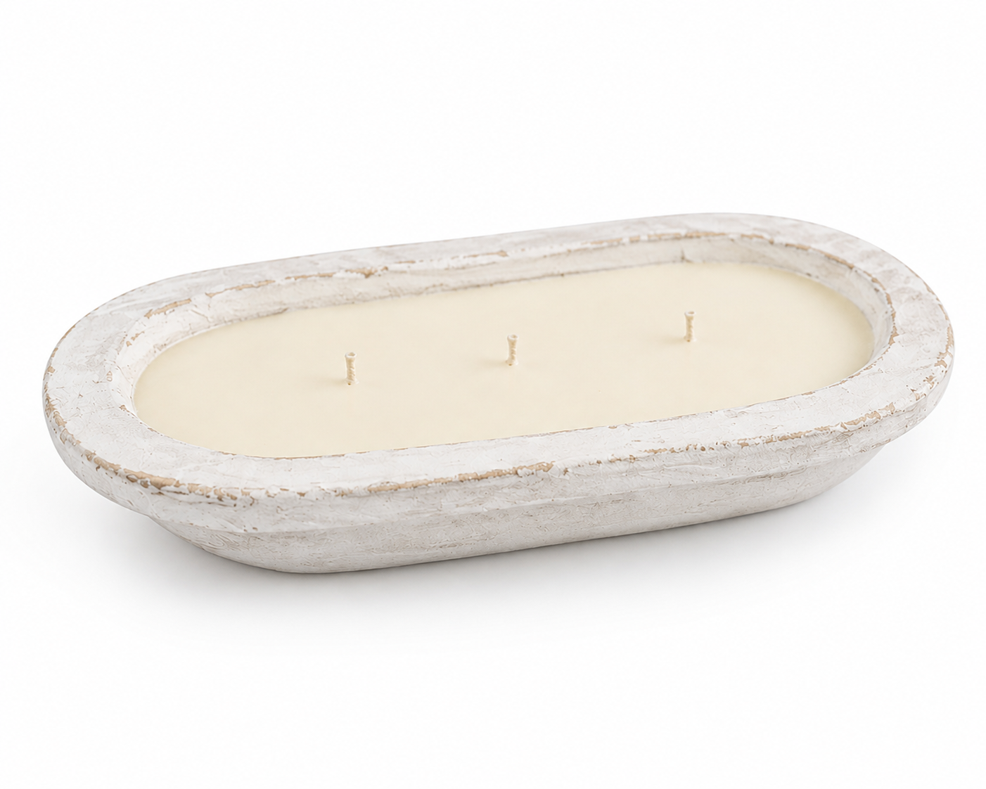 An oval-shaped three-wick candle in a distressed white concrete or stone vessel, photographed on a seamless white background.