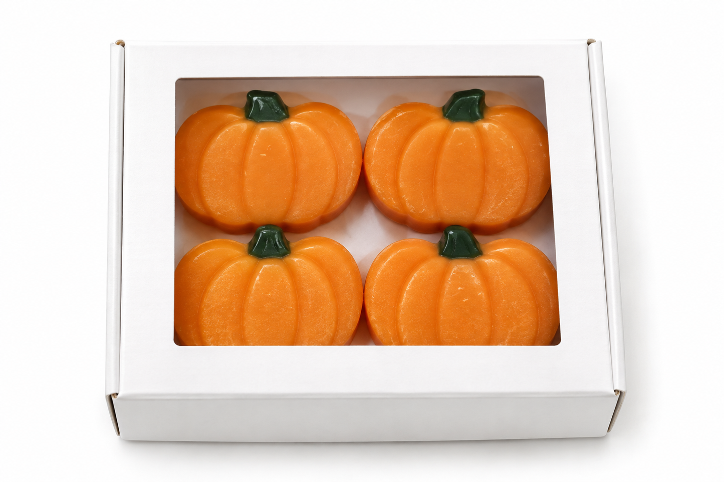 Four orange pumpkin-shaped items arranged in a white square box with a clear front window, photographed on a white background.
