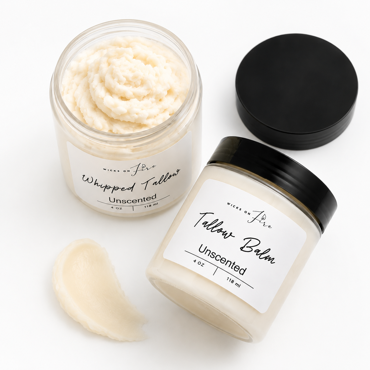 Two clear cosmetic jars of 'Whipped Fattah' Unscented Tallow Balm by Wise of Jericho, one open to show the creamy off-white balm and one closed with a black lid, alongside a small swatch of the balm on a clean white background.